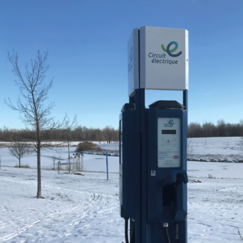 Electric vehicle charging station in front of snowy field